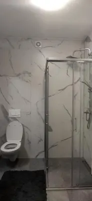 a bathroom with a toilet and a glass shower at Apartman Bonaca in Kiseljak
