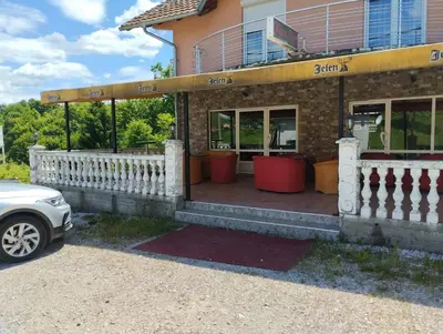 a building with a fence and a car parked in front at Lillis Apartment in Ivišovo Greblje