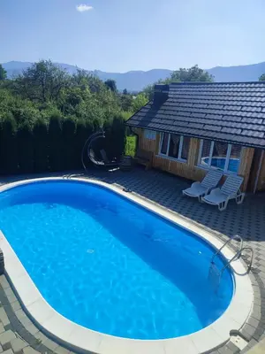 a large blue swimming pool in front of a house at Bihać Kralje in Bihać