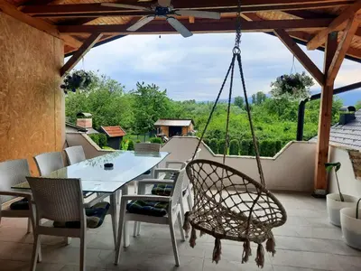 a patio with a table and chairs and a swing at Bihać Kralje in Bihać