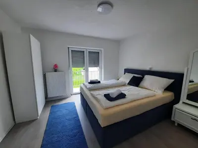 a bedroom with two beds and a blue rug at Bihać Kralje in Bihać