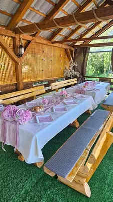 a row of tables in a pavilion with flowers on them at Smjestaj na selu KLARA in Staro Selo