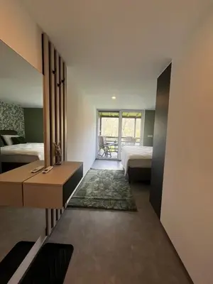 a bedroom with two beds and a desk and a window at Una Meryland in Kulen Vakuf