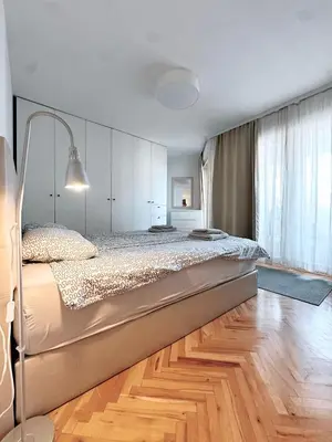 a large bed in a bedroom with a wooden floor at Apartman Lorka in Banja Luka