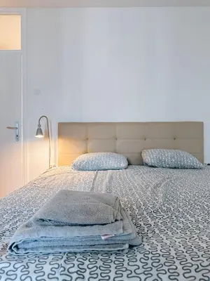 a bed with a blanket and pillows on it at Apartman Lorka in Banja Luka
