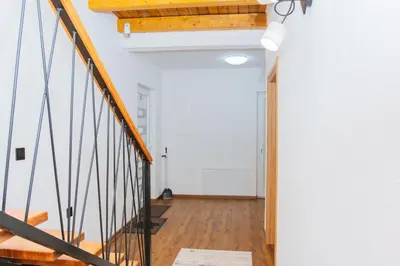 a hallway with white walls and a wooden stair case at UnaSoul in Bihać