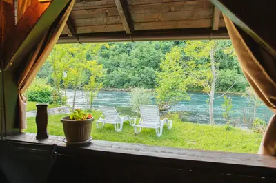 a window view of a yard with chairs and a river at UnaSoul in Bihać