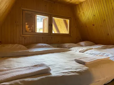 two beds in a room with a window at Planinska kuća Divna in Šišava