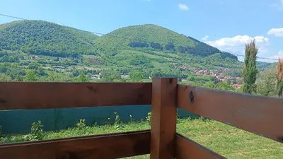 a wooden fence with mountains in the background at Sun-Moon Apartment in Zbilje
