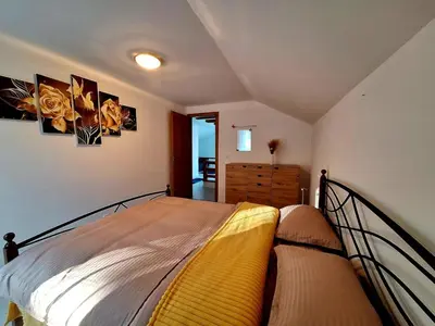 a bedroom with a bed and two pictures on the wall at Villa Forest in Bosanska Gradiška