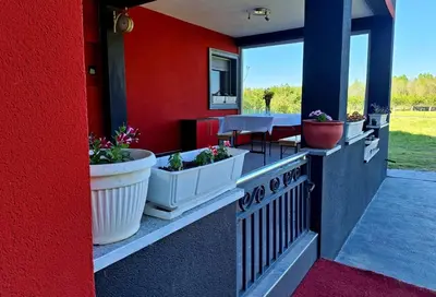 a red wall withotted plants on a patio at Villa Forest in Bosanska Gradiška