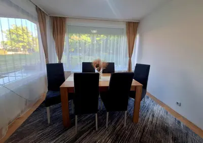 a dining room with a table with chairs and a window at Villa Forest in Bosanska Gradiška