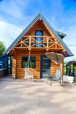 a log cabin with a swing in front of it at Brvnara Tribalija