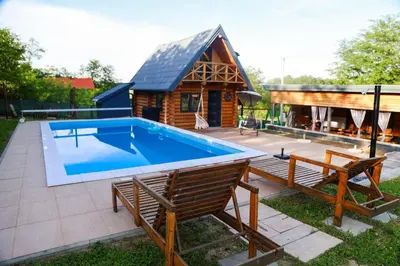 a pool in the backyard of a log house at Brvnara Tribalija