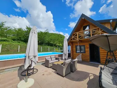 a house with a pool and two umbrellas at Brvnara Tribalija