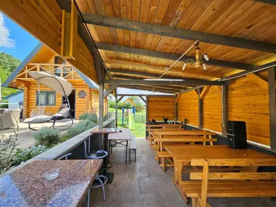 an empty restaurant with wooden tables and benches at Brvnara Tribalija
