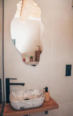 a bathroom with a stone sink and a mirror at Brvnara Tribalija