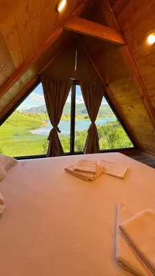a large bed in a room with a large window at Vikendica Malekin in Ripci