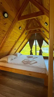 a large bed in a room with a wooden ceiling at Vikendica Malekin in Ripci