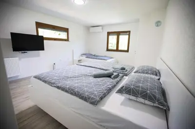 a bedroom with two beds and a flat screen tv at Villa Ella in Bihać