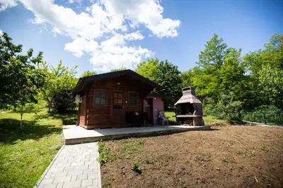 a small wooden cabin in a field with a yard at Villa Ella in Bihać