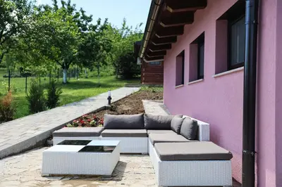 a couch sitting outside of a pink building at Villa Ella in Bihać