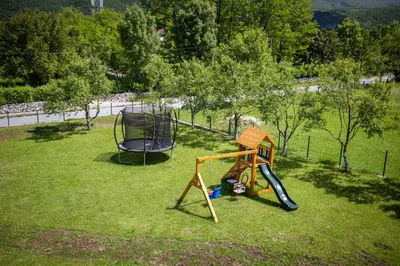 a playground with a swing and a chair in the grass at Villa Ella in Bihać