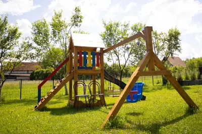 a wooden playground with a slide in the grass at Villa Ella in Bihać