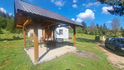 a small house with a roof on a field at Planinska kuća Bajni