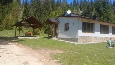 a building with a bench in front of it at Planinska kuća Bajni