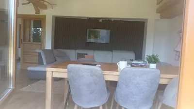 a dining room table with chairs and a couch at Planinska kuća Bajni