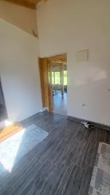 an empty room with wood floors and a wall at Planinska kuća Bajni