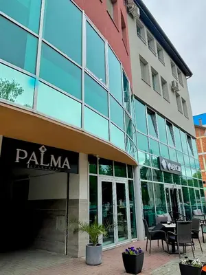 a building with a palaia sign in front of it at Sobe PALMA in Sanski most