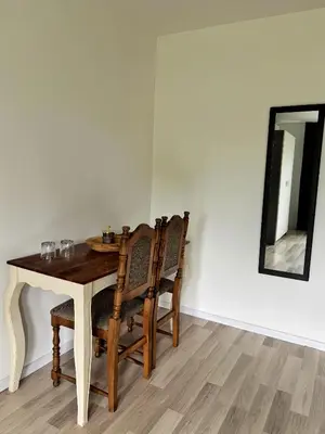 a dining room table with chairs and a mirror at Sobe PALMA in Sanski most