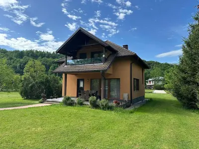 a small house in a field with a green yard at Cottage on Una in Bihać