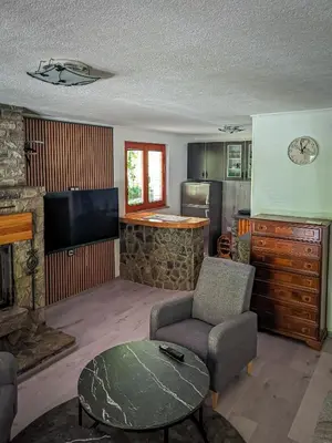a living room with a fireplace and a tv at Vikendica Stella in Bihać