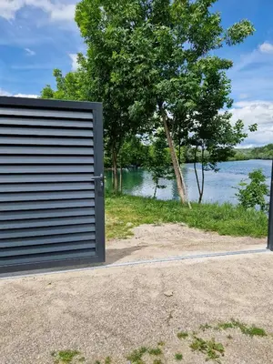 a garage door in front of a body of water at Apartman A&A in Ivišovo Greblje