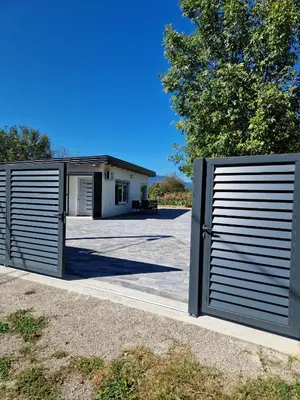 a pair of gates in front of a garage at Apartman A&A in Ivišovo Greblje