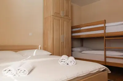 two beds in a room with two bunk beds at Kuća za odmor KUNA in Kupres
