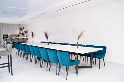 a long table with blue chairs in a room at Villa Maison de luxe in Laktaši