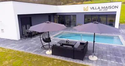 a pool with two tables and two umbrellas next to it at Villa Maison de luxe in Laktaši