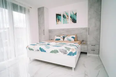 a white bedroom with a bed in a room at Villa Maison de luxe in Laktaši