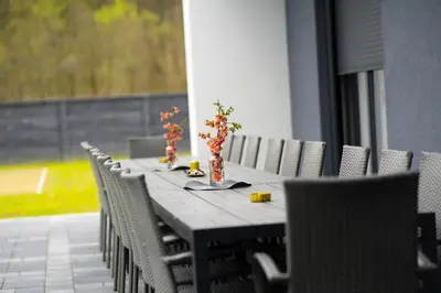 a long table with chairs and vases on it at Villa Maison de luxe in Laktaši