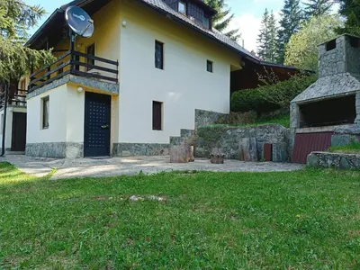 a white house with a blue door and a yard at Vlasic Relax Location in Vlasic