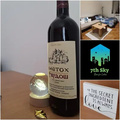 a bottle of wine sitting on a table with a candle at 7th Sky in Banja Luka