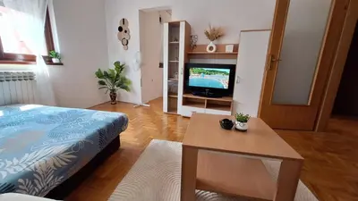 a room with a bed and a table and a television at 7th Sky in Banja Luka