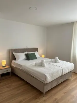 a bedroom with a large bed with two towels on it at Apartmani Pervan 2 in Livno