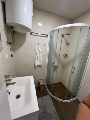 a bathroom with a shower with a sink and a shower at Apartmani Pervan 2 in Livno