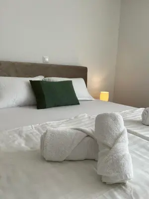 a white bed with two folded towels on it at Apartmani Pervan 2 in Livno