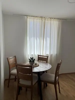 a dining room with a table and chairs and a window at Apartmani Pervan 2 in Livno